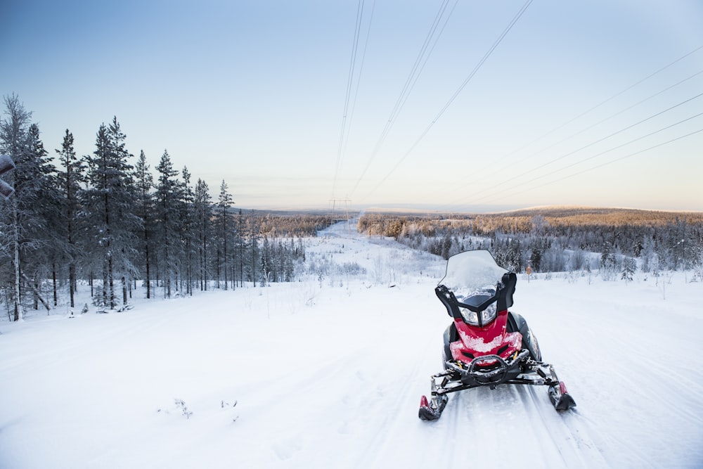 person riding snow mobile on snow covered field during daytime