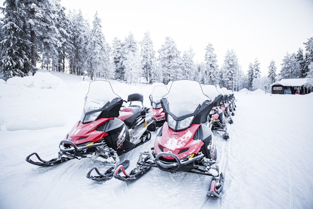 Moto de nieve negra y naranja en suelo cubierto de nieve