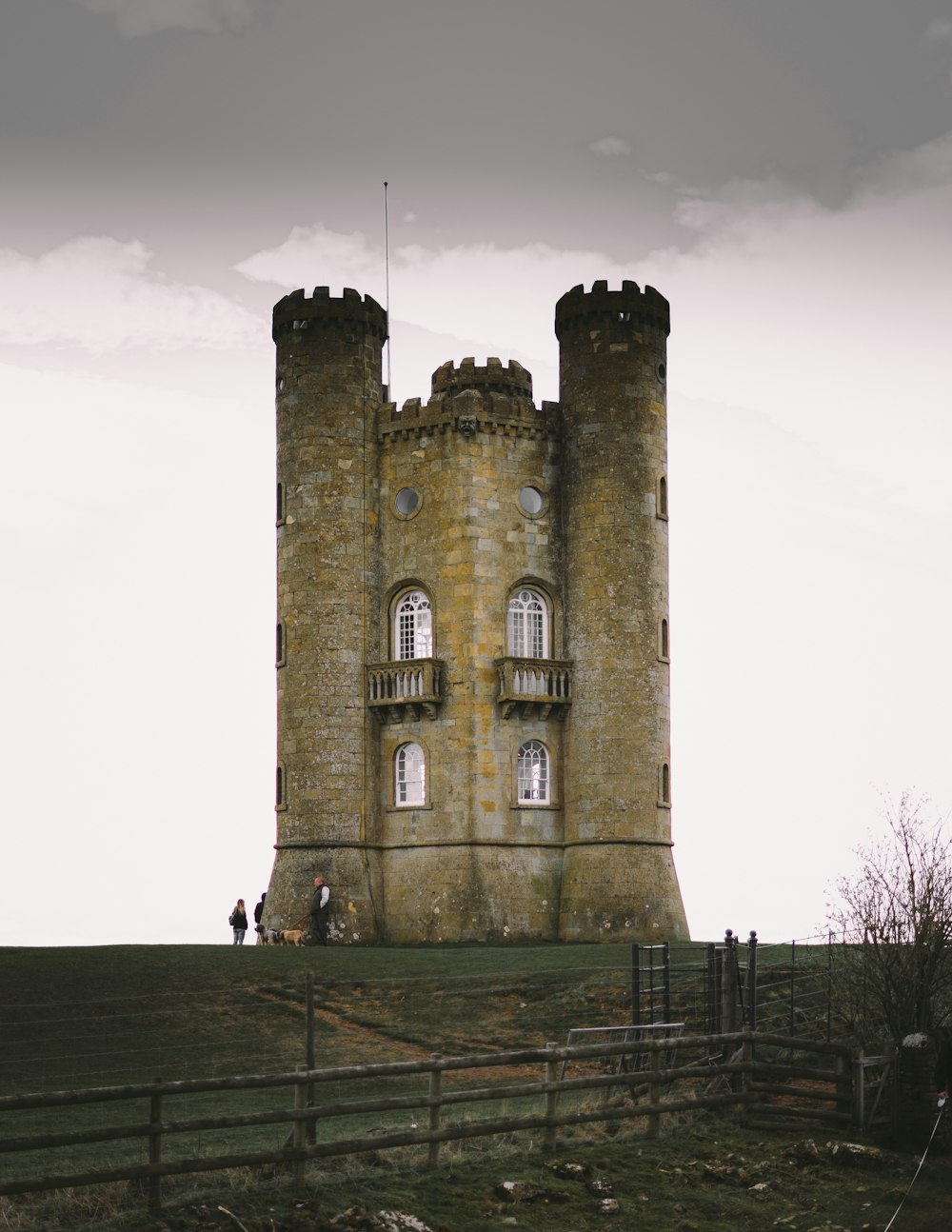 a tall tower with two windows on top of a hill
