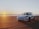 A modern rental car parked on a sunny beach.