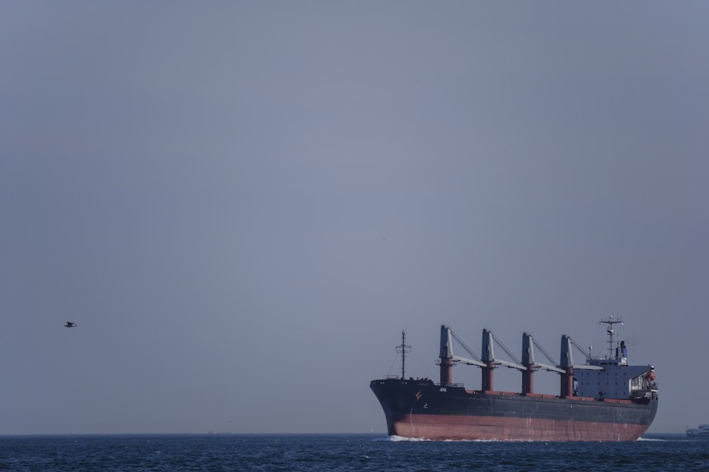 Navire rouge sur la mer sous le ciel gris