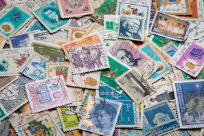 Vintage postage stamps arranged artistically on a wooden surface.