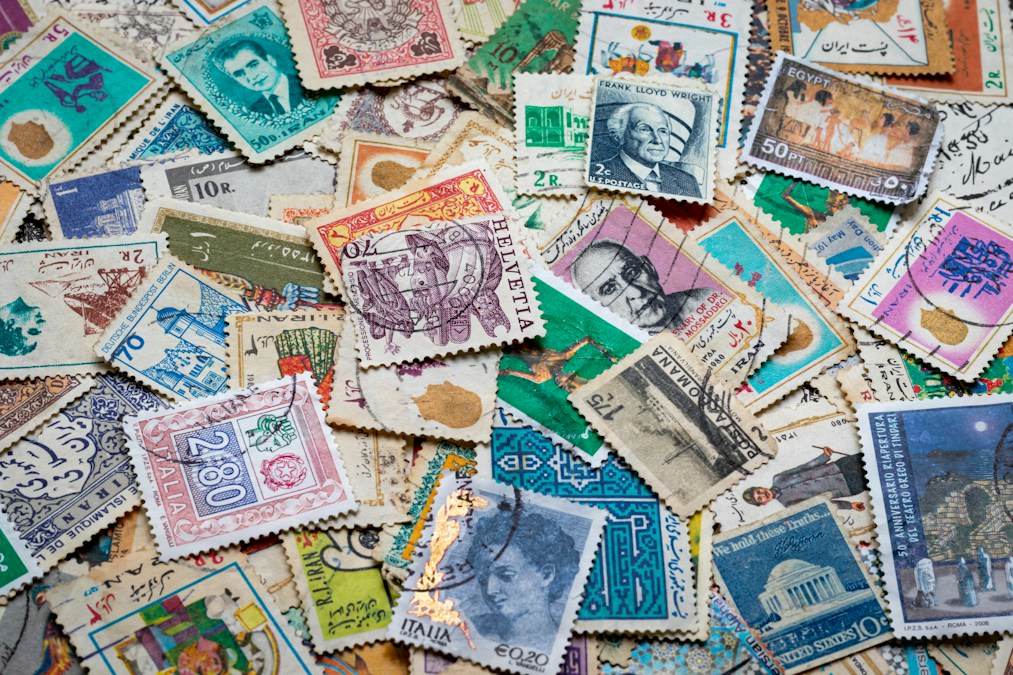 Timbres-poste de différents pays et époques étalés en vrac sur une table