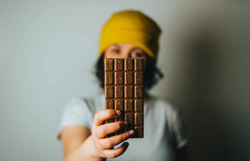 person holding brown cone with yellow cap