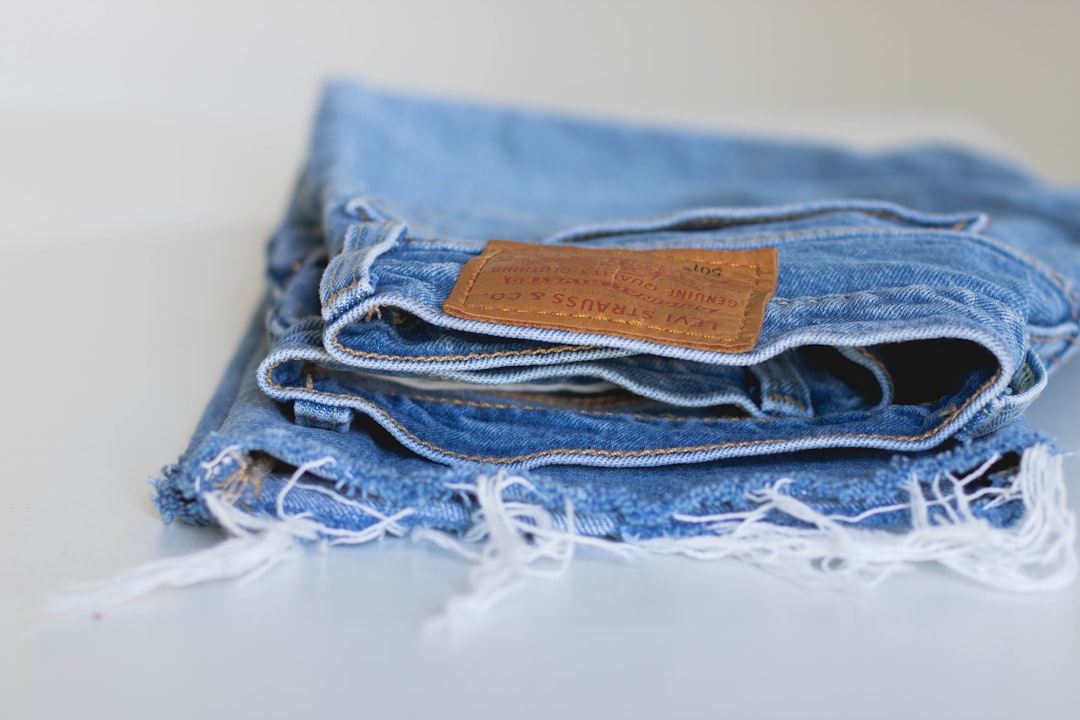 blue denim jeans on white textile