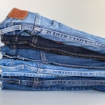 blue denim jeans on white textile