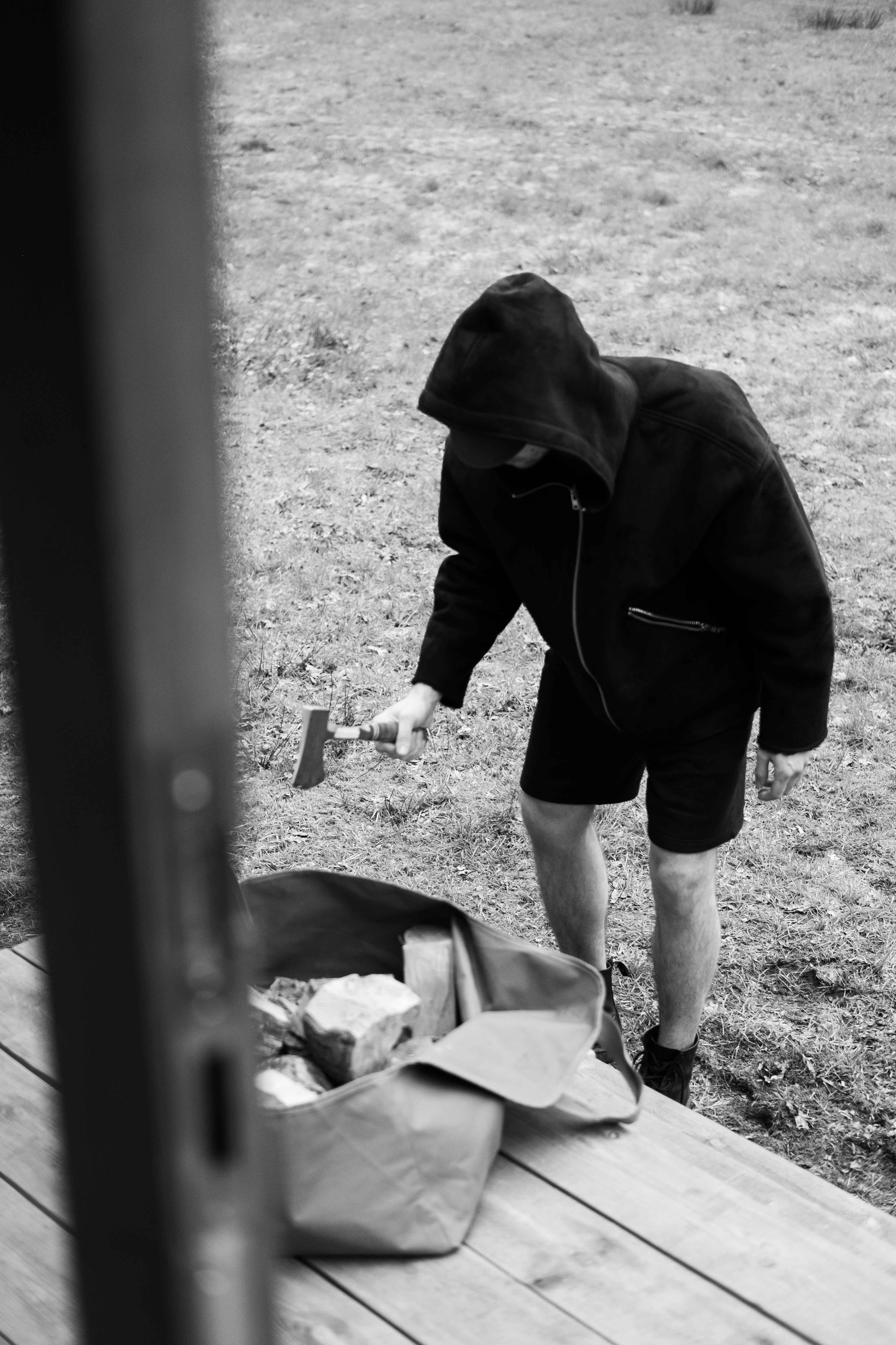 man in black hoodie and black shorts holding a black smartphone