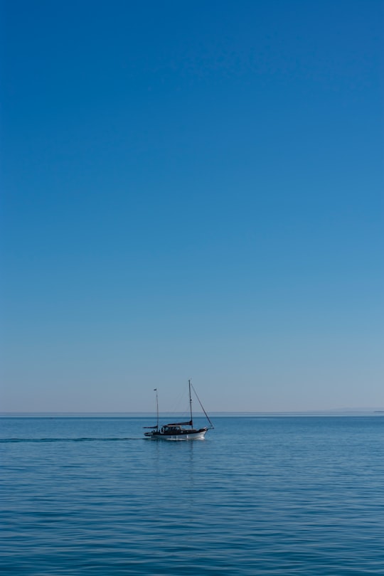 white sailboat on sea under blue sky during daytime in Setúbal Portugal