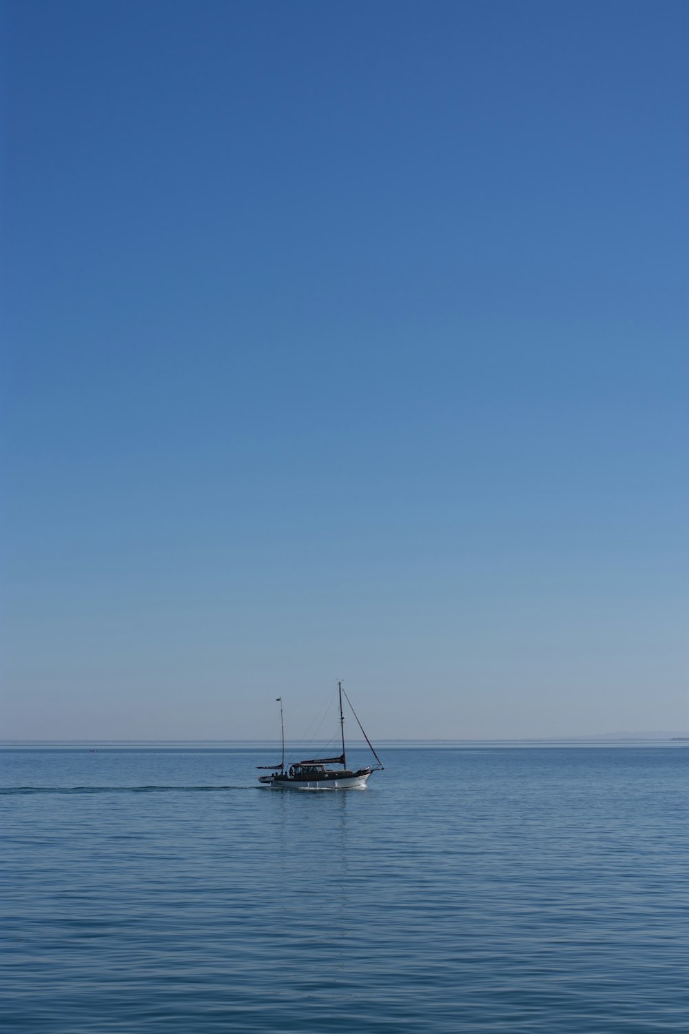 velero blanco en el mar bajo un cielo azul durante el día
