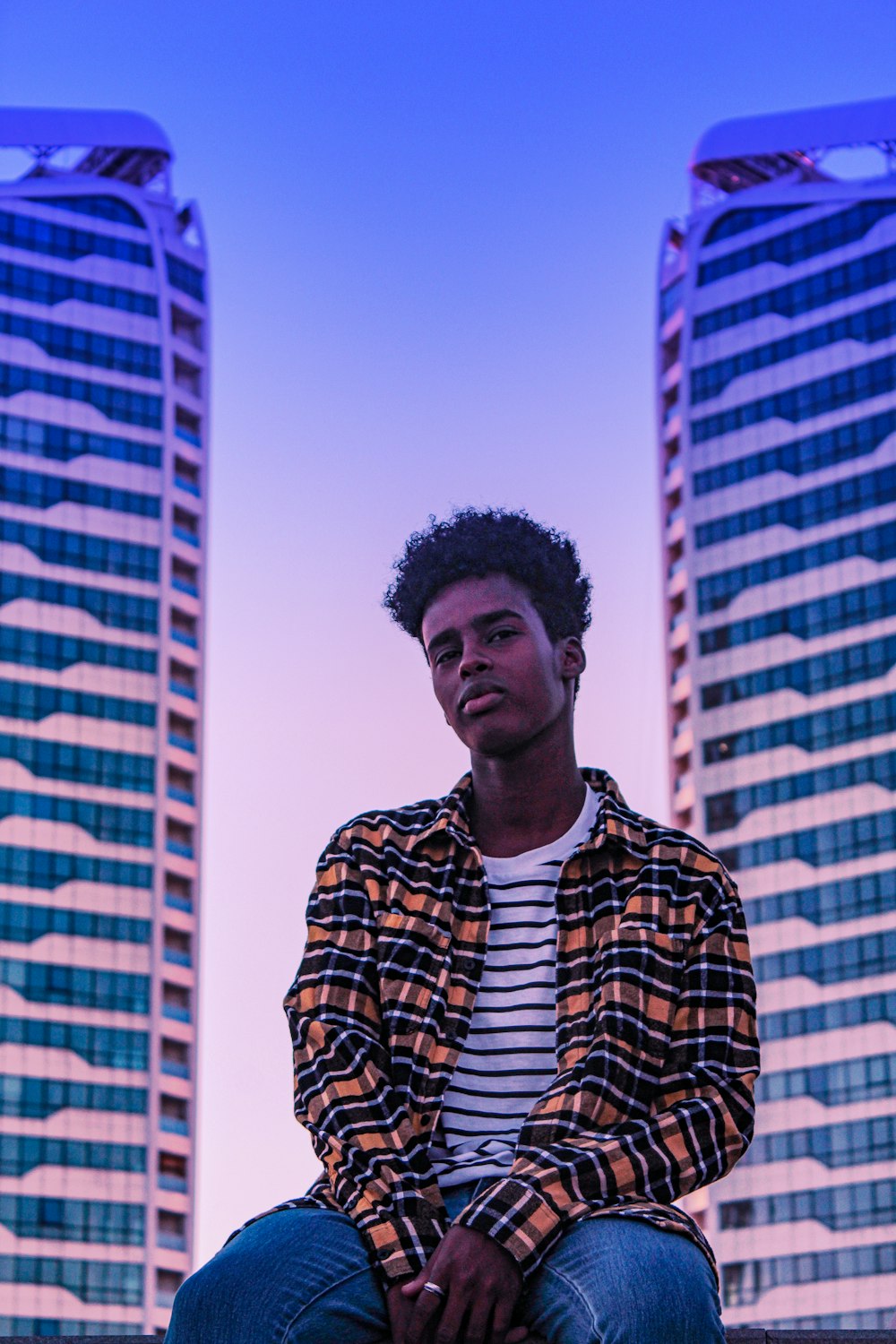 man in black and white striped zip up jacket standing near building during daytime