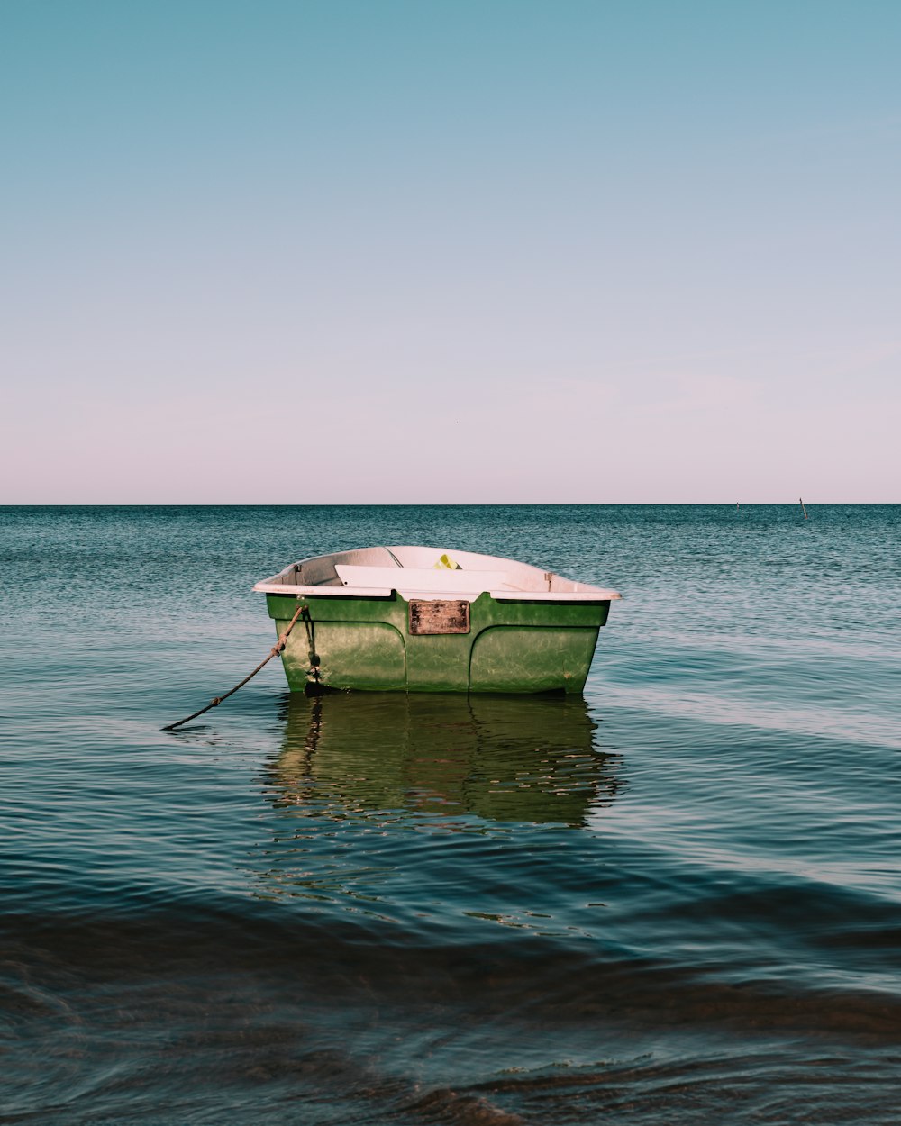 white and green boat on sea during daytime