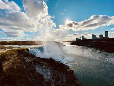 water falls under blue sky and white clouds during daytime