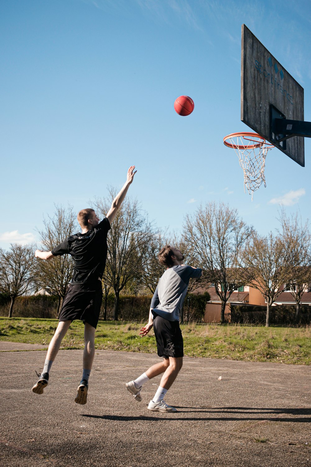 2 women playing basketball during daytime