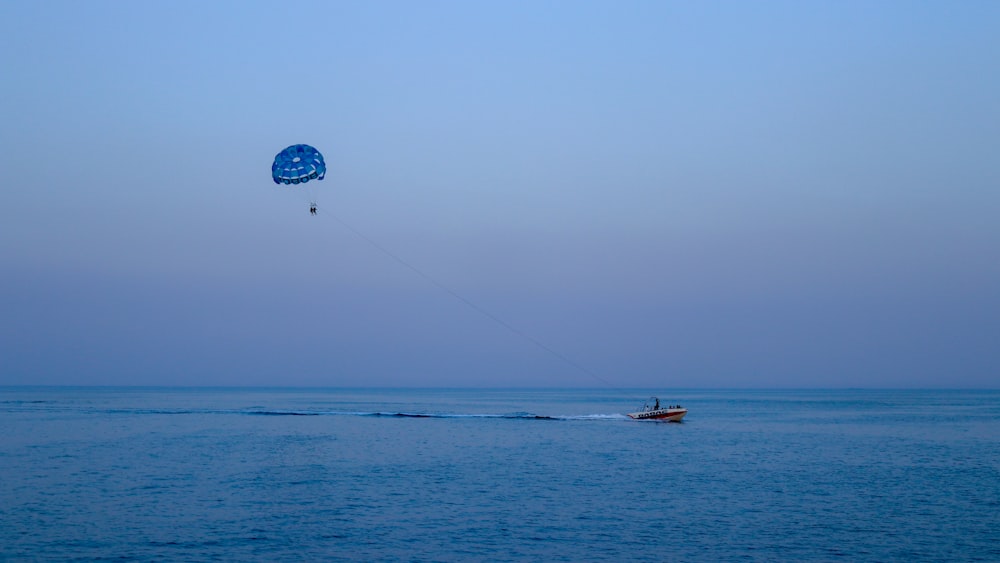 blue and white balloon floating on blue sea during daytime