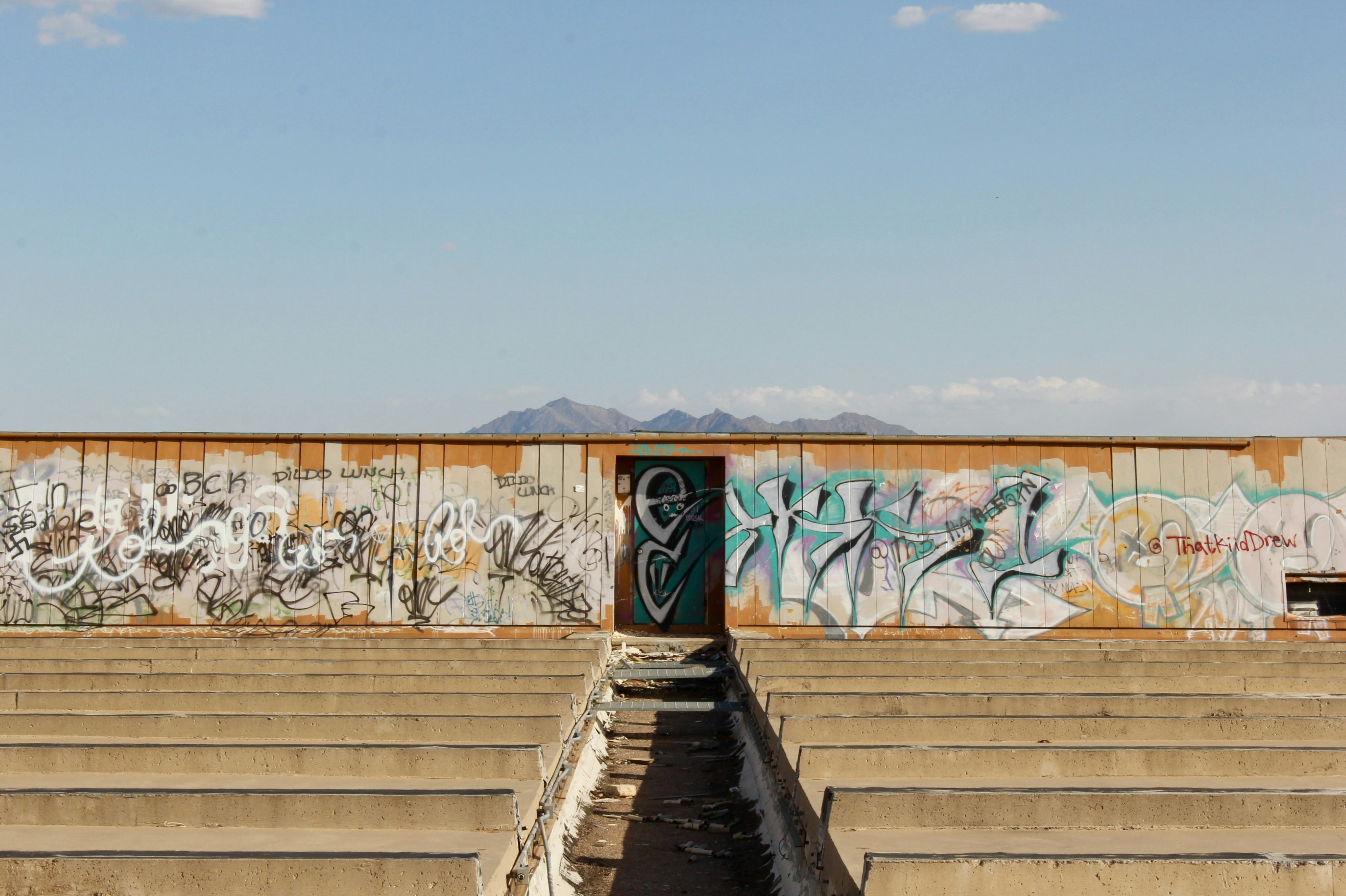 brown wooden stairs with graffiti on wall during daytime