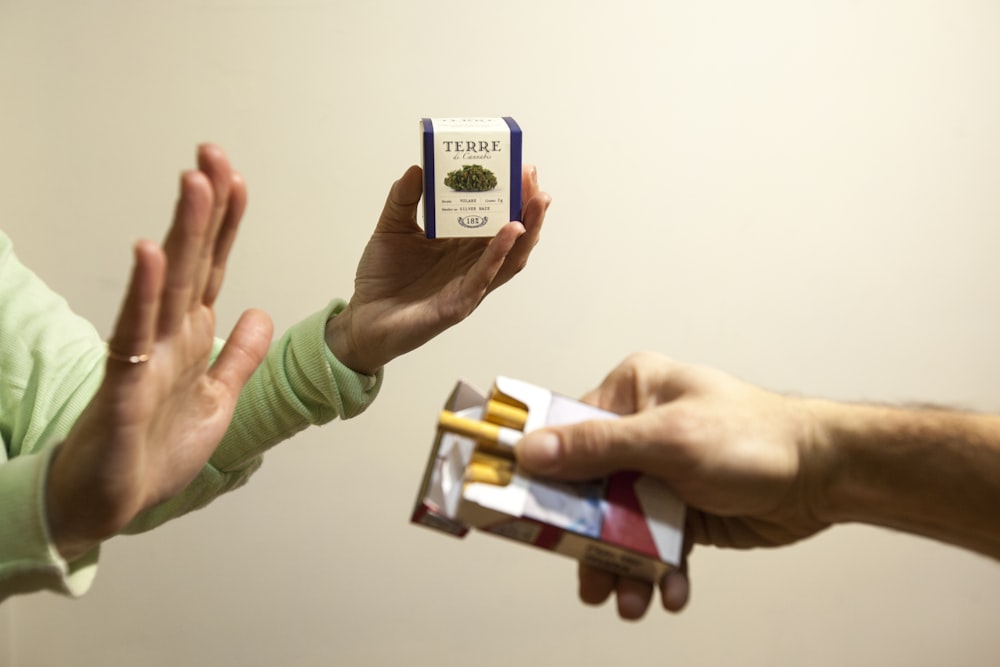 person holding white and black labeled box