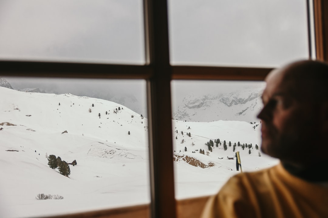 person in brown jacket standing on snow covered ground during daytime