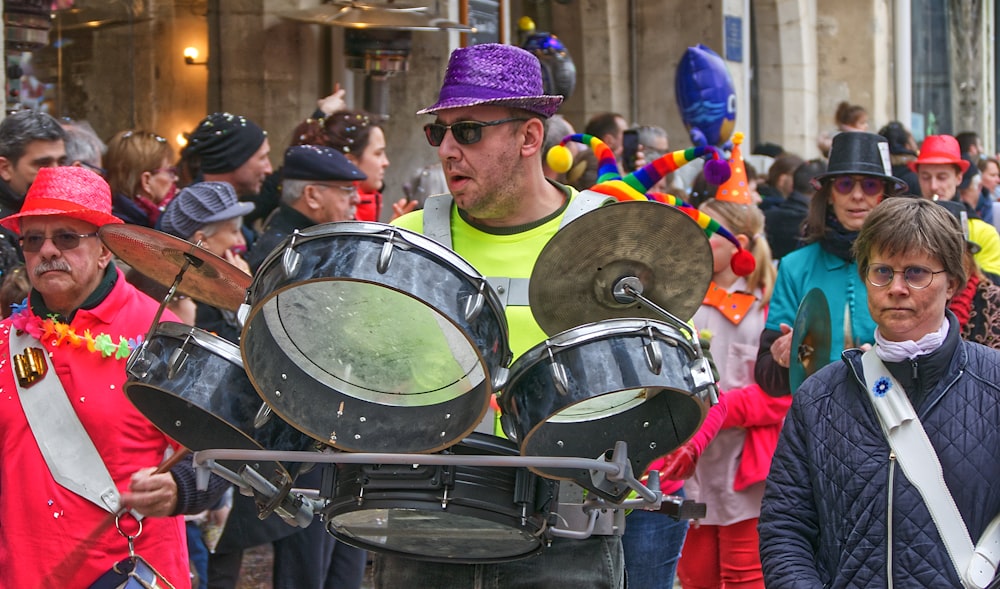 man in green and blue hat playing drum