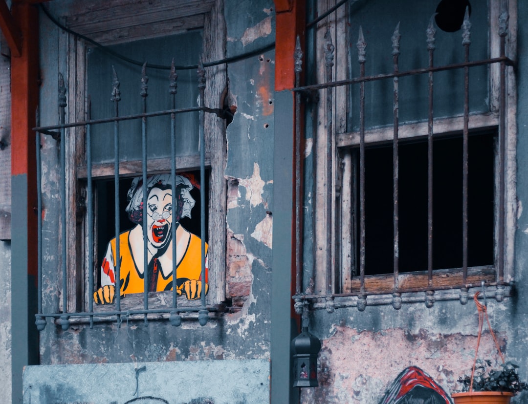 man in black and yellow mask graffiti on gray concrete wall