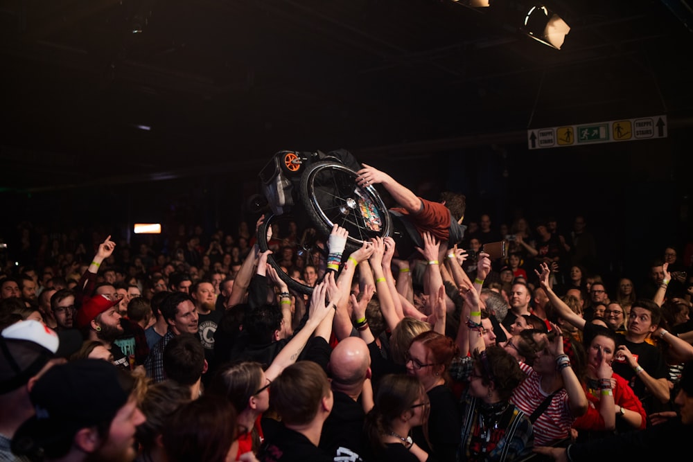 people raising their hands in front of crowd