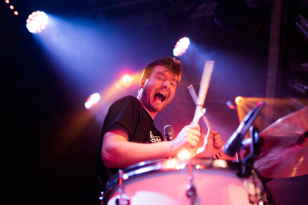 man in black crew neck t-shirt playing drum