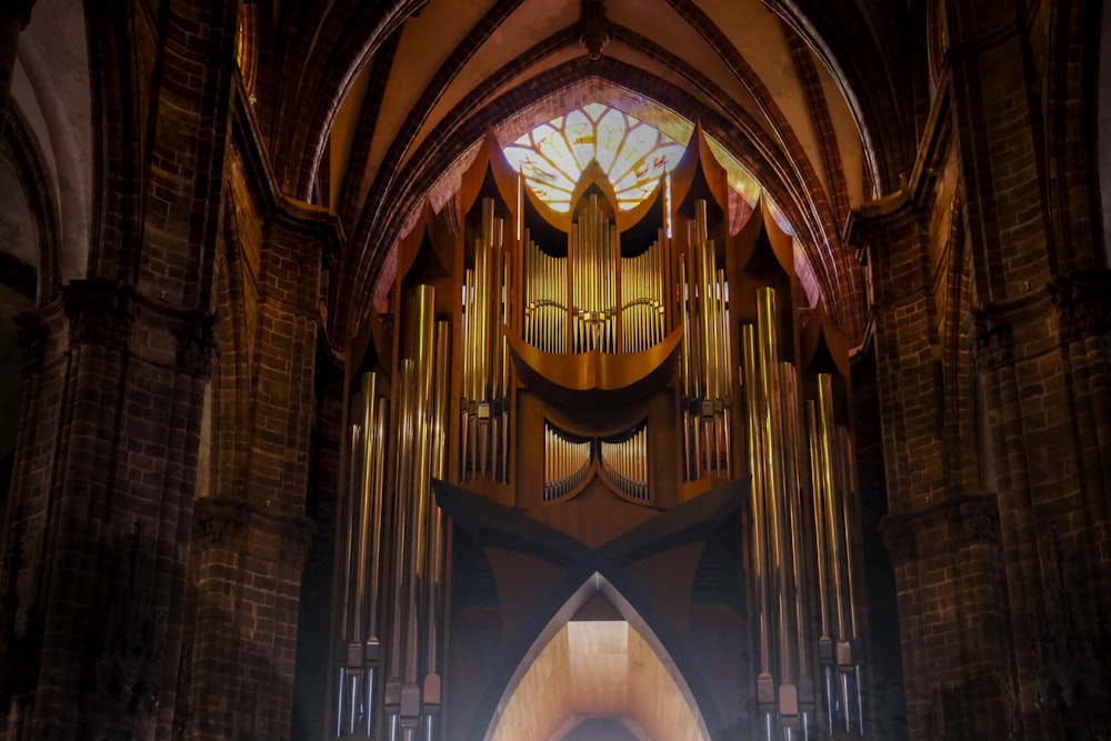 a large pipe organ in a church with a stained glass window