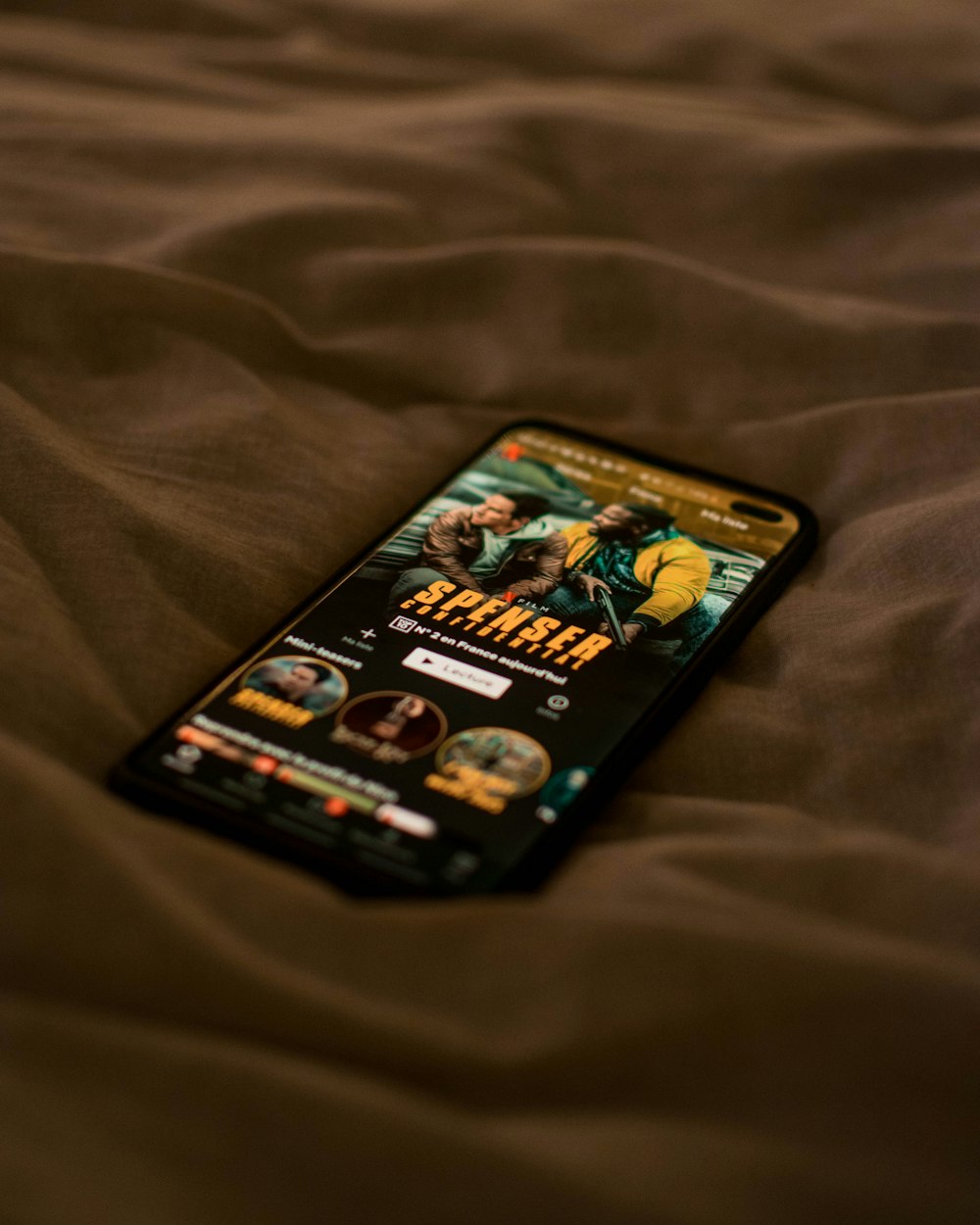 Schwarzes Android-Smartphone auf braunem Textil