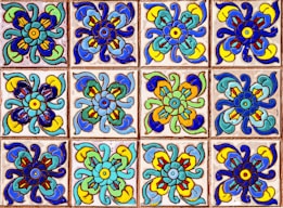 A collection of colorful decorative tiles featuring intricate floral patterns. Each tile displays a symmetrical design with vivid hues of blue, green, yellow, and red, arranged in a repetitive grid.