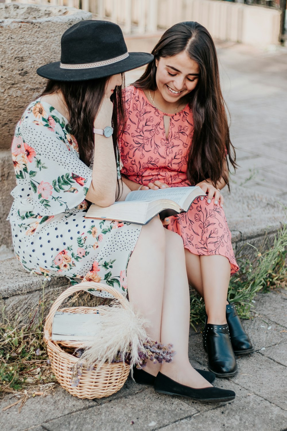 woman in red and white floral dress sitting on brown woven basket