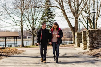 A scenic park setting with people walking hand in hand.