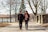 A couple smiling and holding hands during a peaceful walk in the park.