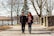 A couple smiling and holding hands during a peaceful walk in the park.