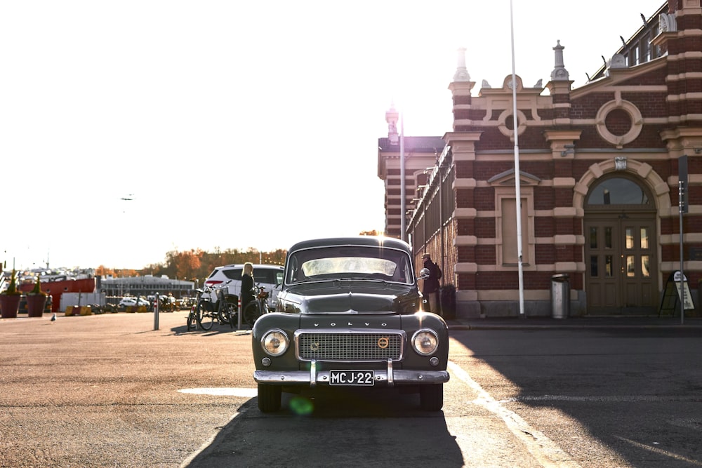 black and green classic car parked on the side of the road