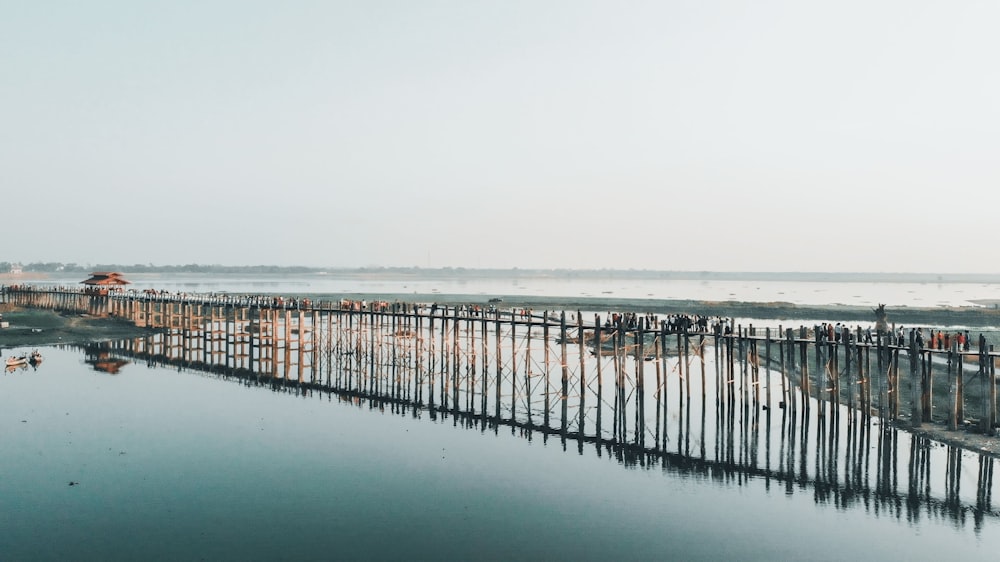 muelle de madera marrón en el mar bajo el cielo blanco durante el día