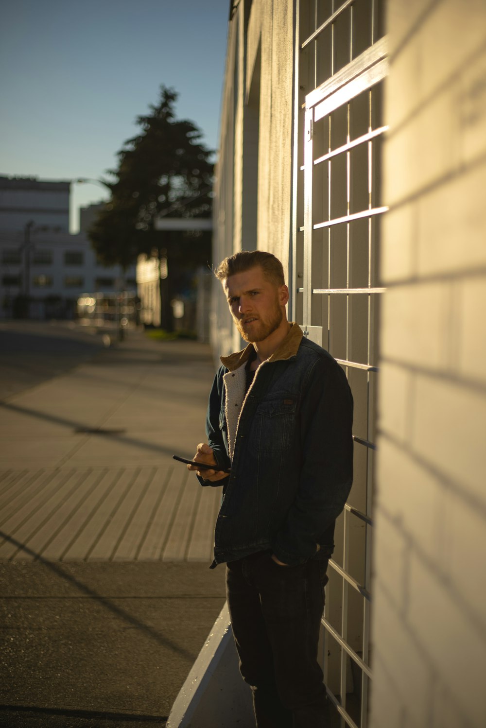 man in black suit jacket standing beside building during daytime