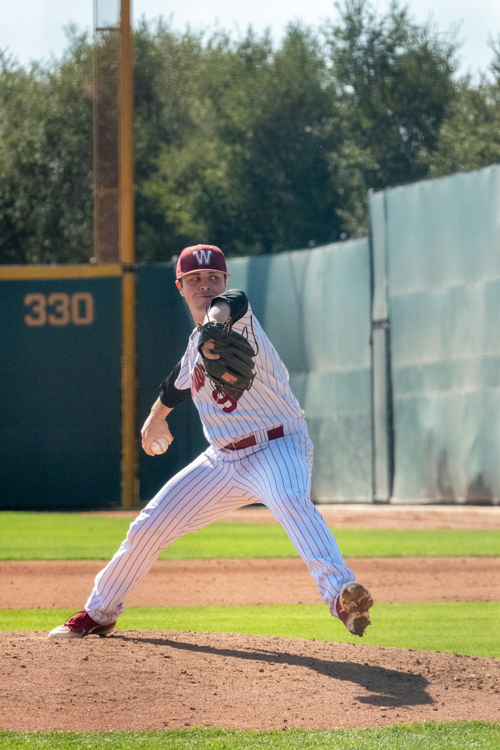 man in white jersey shirt and pants holding baseball bat