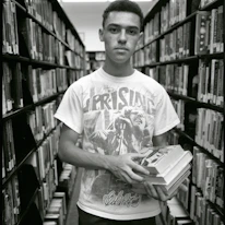 A young student proudly holding books received through our education support program.