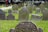 A satisfied customer standing next to a beautifully designed gravestone.