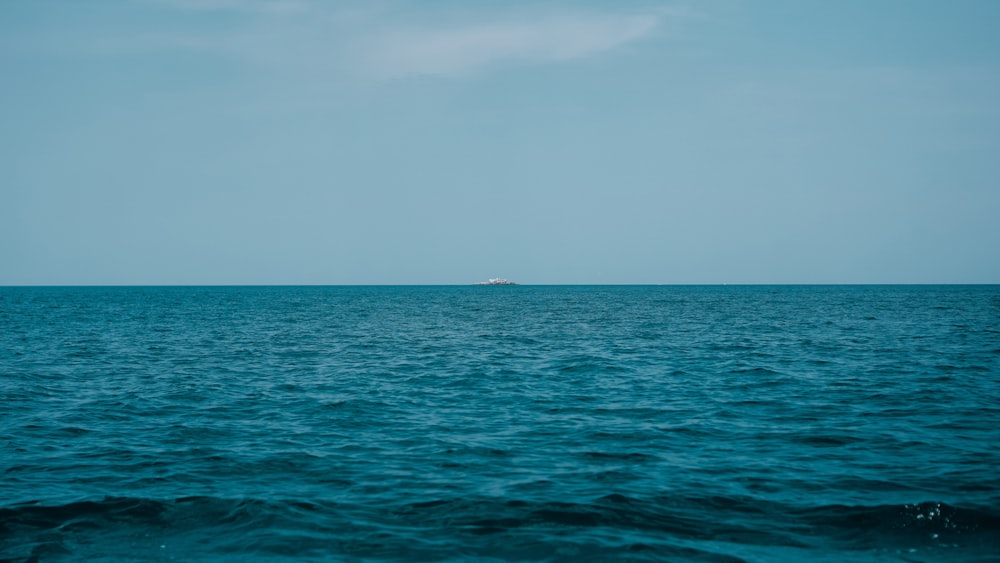 body of water under white sky during daytime