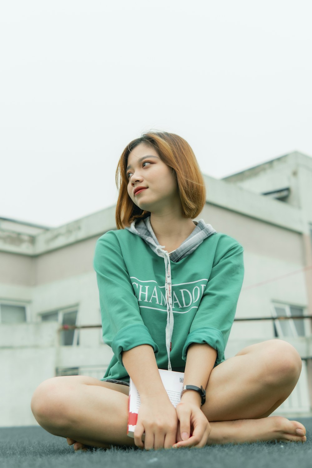 woman in blue zip up jacket sitting on brown wooden bench during daytime