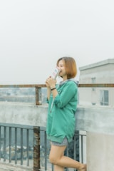 A person smiling while reading an ebook on a sunny balcony.