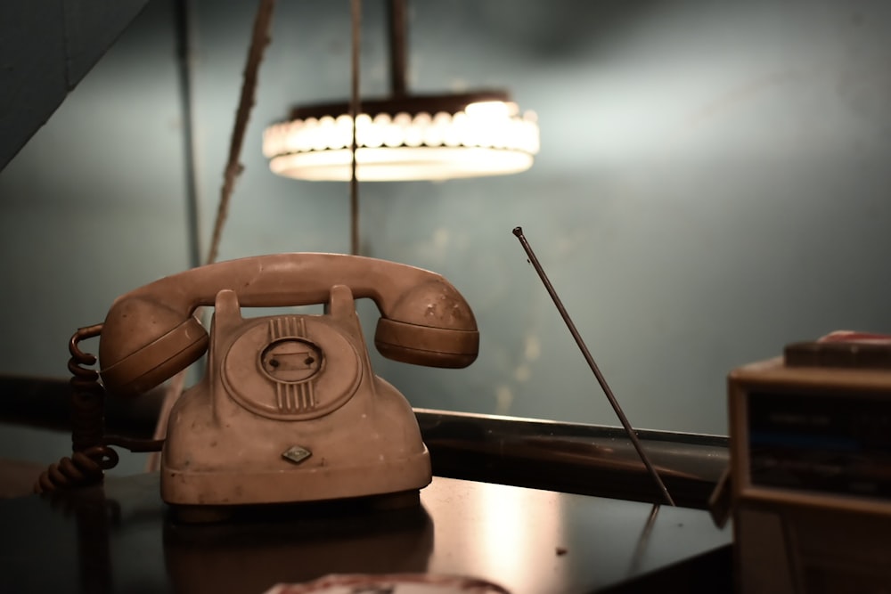 brown rotary telephone on brown wooden table