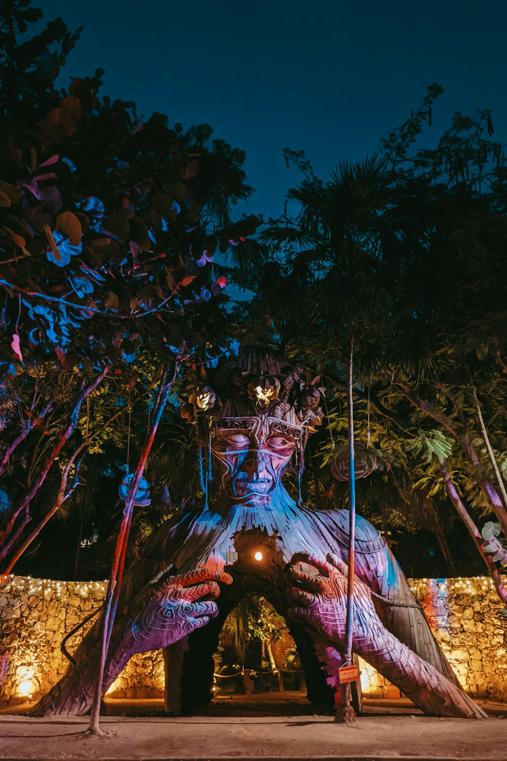 hindu deity statue near trees during night time