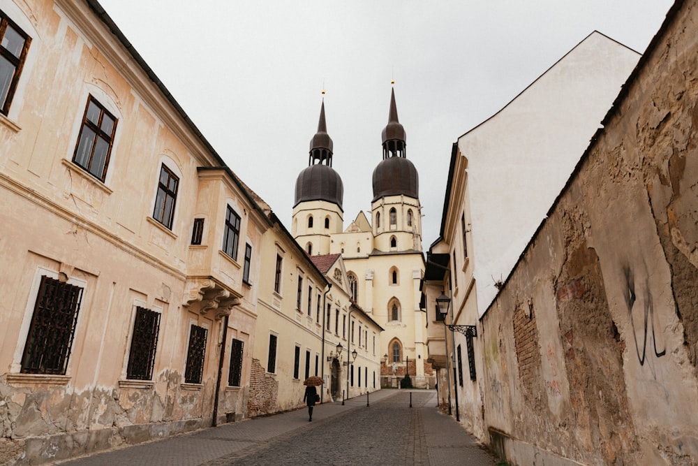 a narrow street with a church in the background