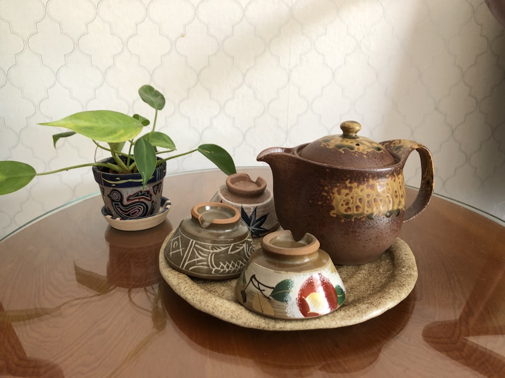 white and brown ceramic teapot on brown wooden tray