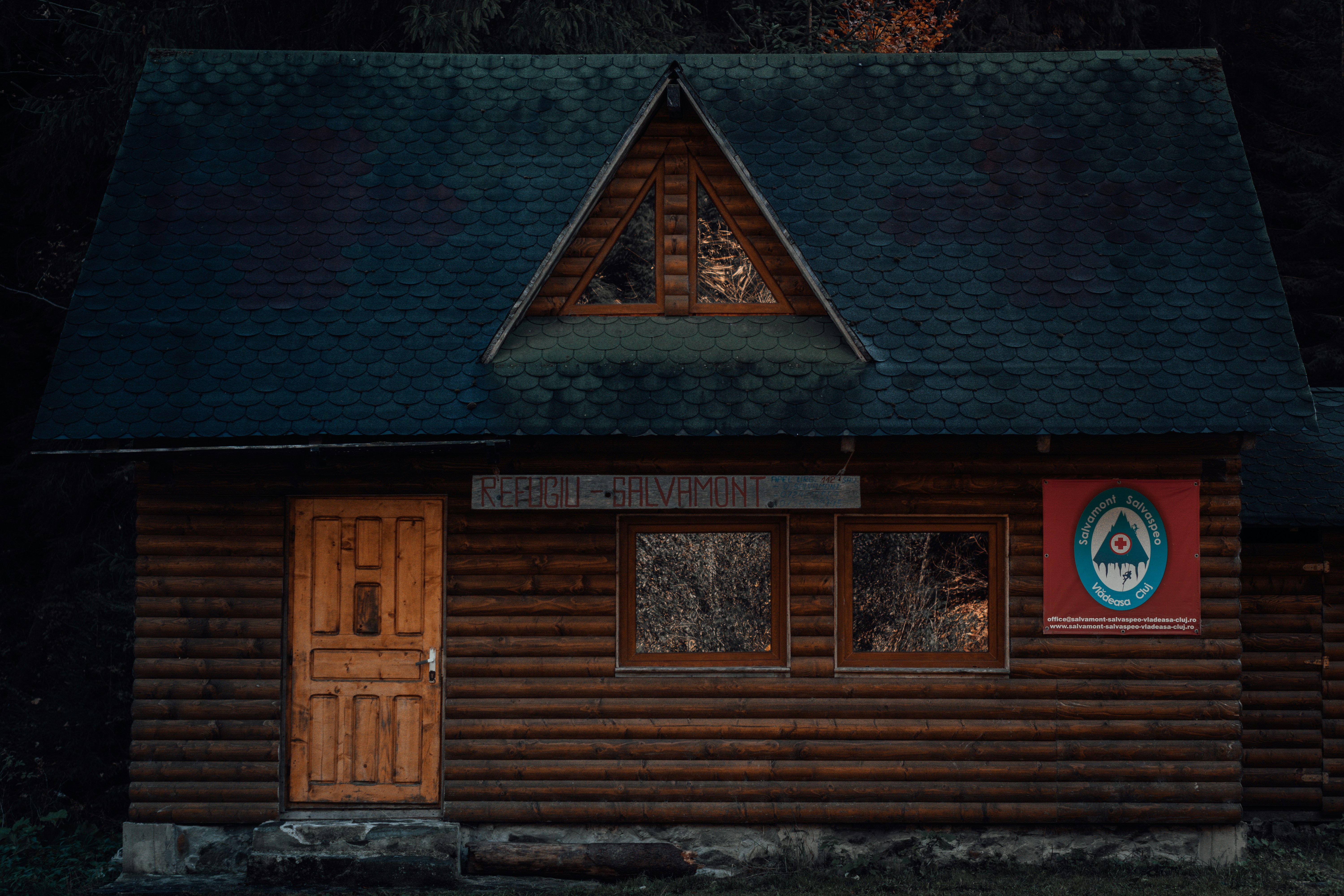 brown wooden door on gray concrete wall, Mountain Rescue Cabin in the woods.