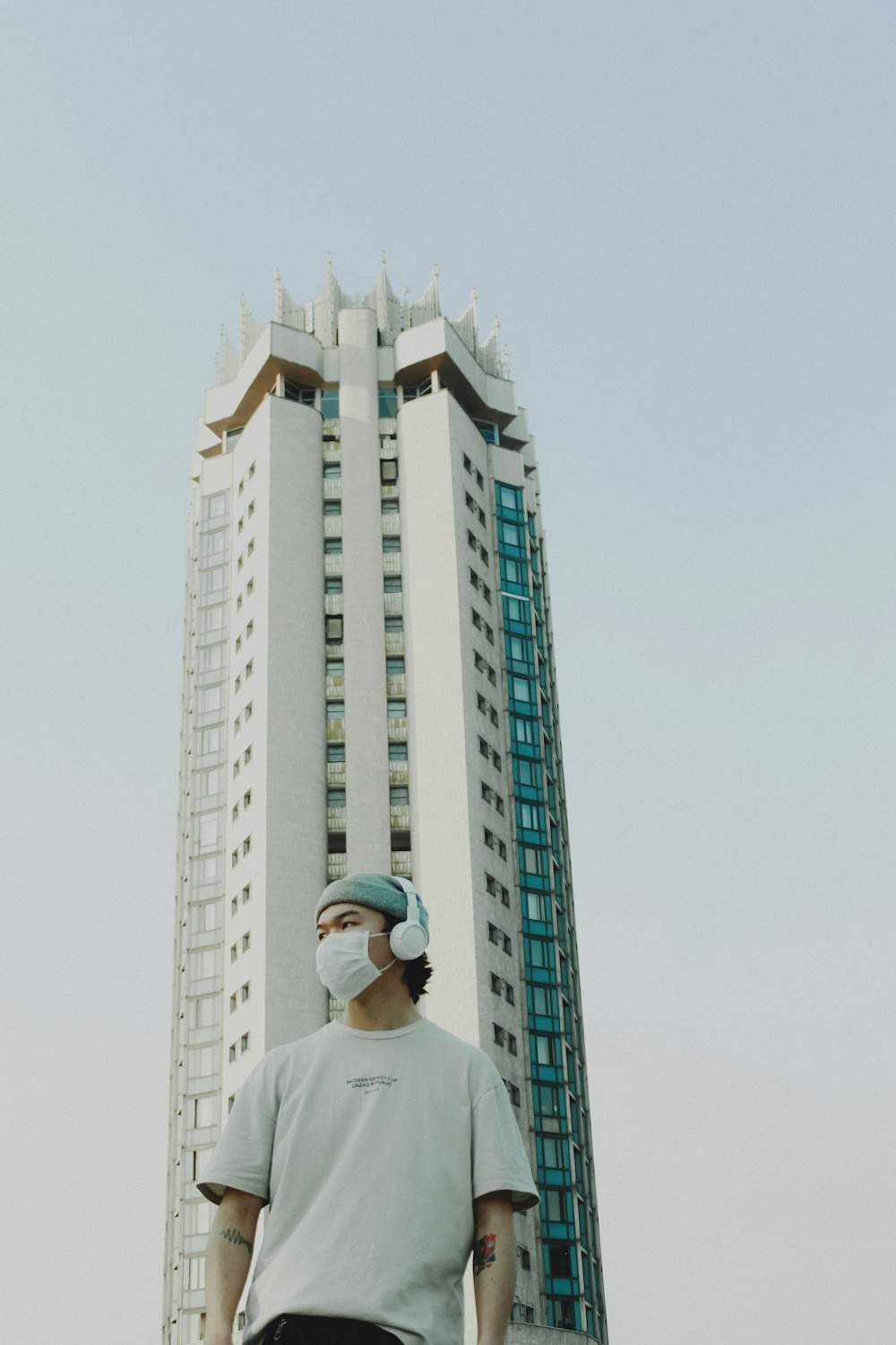 uomo in camicia bianca in piedi vicino a grattacieli durante il giorno