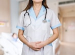 woman in white button up shirt and blue stethoscope