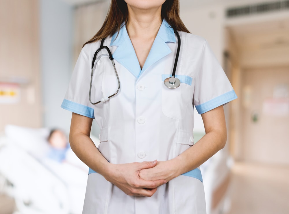 donna in camicia bianca abbottonata e stetoscopio blu