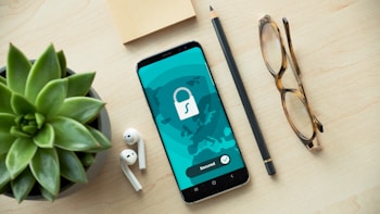 phone beside glasses and desk items